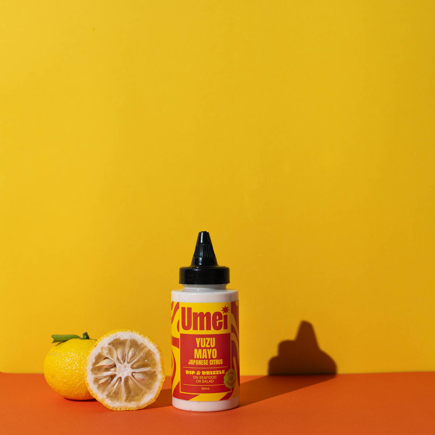 Umei Yuzu Mayo and yuzu fruit on orange background